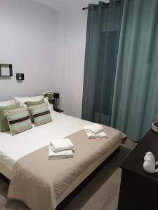 - une chambre avec un lit et des serviettes dans l'établissement Helena's house, à Ermoúpoli