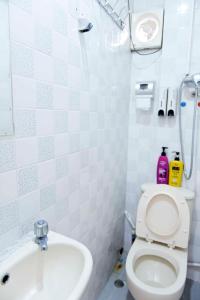 a small bathroom with a toilet and a sink at Ah Shan Hostel in Hong Kong