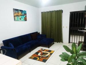 a living room with a blue couch and a rug at Casa Abundancia in Aguas Zarcas