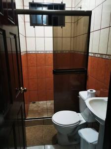 a bathroom with a toilet and a sink at Casa Abundancia in Aguas Zarcas