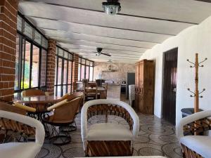 comedor con sillas, mesas y ventanas en Casa San Pedro, en San Pedro Tesistán