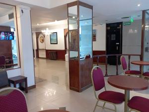a lobby with tables and chairs in a building at Gran Hotel Augusto in Mar del Plata