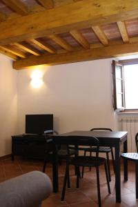 - un salon avec une table, des chaises et une télévision dans l'établissement Locanda Il Monastero, à Ortonovo