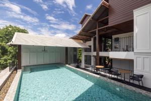 ein Swimmingpool im Hinterhof eines Hauses in der Unterkunft Coucou Hotel in Chiang Mai