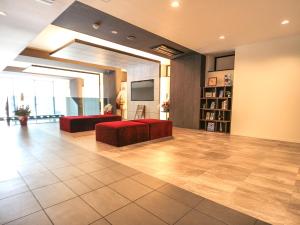 a large room with two couches and a flat screen tv at HOTEL LiVEMAX Sapporo Susukino in Sapporo