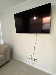 a flat screen tv hanging on a white wall at Departamento Vista Herradura Coquimbo in Coquimbo