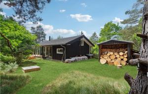een huis met een stapel houtblokken in de tuin bij Gorgeous Home In Aakirkeby With Kitchen in Vester Sømarken