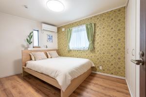 a bedroom with a bed and a window at Ici Japon Village in Tokyo