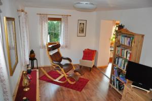 a living room with a chair and a book shelf at Ferienhaus Sapplerhof in Millstatt