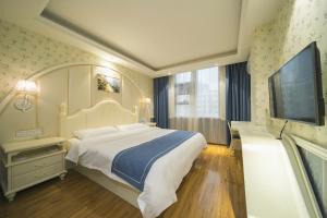 a bedroom with a large bed and a flat screen tv at Morninginn, Tujiachong Metro Station in Changsha