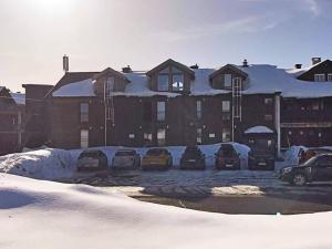 a building with cars parked in a parking lot covered in snow at 4 person holiday home in GEILO-By Traum in Geilo