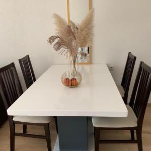 a white dining room table with a vase on it at Apartman TESA in Sanski most