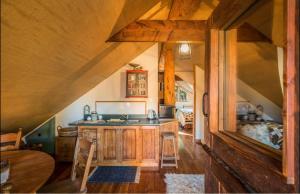 a kitchen with wooden cabinets and a table in a house at Magical Loft - Homewood Forest Retreat in Alexandra