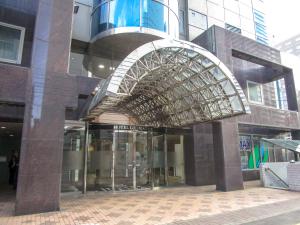 a large building with an archway in front of it at HOTEL LiVEMAX SAPPORO NAKAJIMA PARK GRANDE in Sapporo