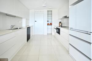 a white kitchen with white counters and appliances at Alexandra Headland Ocean Dream - Stunning View ZA6 in Alexandra Headland