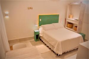 朱奎Casa d'Aroeira Residencial Boutique - Centro de Juqueí - 2 quadras do mar - Serviço de Praia - Roupa de Cama 600 fios algodão Egípcio - Toalhas Banho e Praia - Tudo Novo - Estacionamento Interno - Cozinha - Consulte unidades com Ofurô Hidro e Cromoterapia的一间带床和椅子的小卧室 更多37张照片