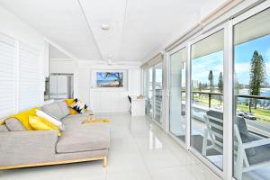 a living room with a couch and large windows at Alexandra Headland Ocean Dream - Stunning View ZA6 in Alexandra Headland