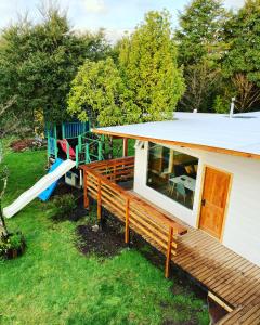 a small house with a deck and a slide at El Viloche - Tiny House in Puerto Montt