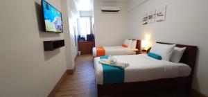 a hotel room with two beds and a tv at Voyager Sun & Reef Hotel in San Pedro