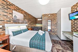 a hotel room with a bed and a tv at Apple & Grape Motel in Stanthorpe