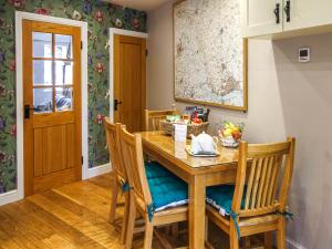 Brantingham的住宿－Pond View Cottage，一间带木桌和椅子的用餐室