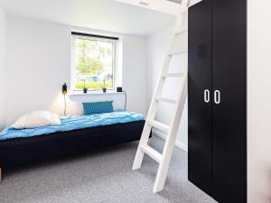 - une chambre avec des lits superposés et une échelle dans l'établissement Holiday home Otterup XII, à Otterup