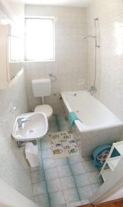 a bathroom with a tub and a toilet and a sink at Apartments Slavica - free WiFi in Vodice