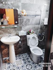 y baño con aseo y lavamanos. en Full House B&B, en Xiaoliuqiu