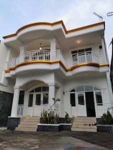 Cette maison blanche dispose d'un balcon. dans l'établissement Wubao Villa dekat hotel Le Eminence Kota Bunga, à Cikundul