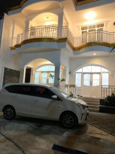 une voiture blanche garée devant une maison dans l'établissement Wubao Villa dekat hotel Le Eminence Kota Bunga, à Cikundul