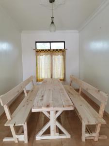 - une table de pique-nique en bois dans une pièce avec fenêtre dans l'établissement Wubao Villa dekat hotel Le Eminence Kota Bunga, à Cikundul
