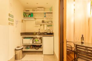 Casa d'Aroeira Residencial Boutique - Centro de Juqueí - 2 quadras do mar - Serviço de Praia - Roupa de Cama 600 fios algodão Egípcio - Toalhas Banho e Praia - Tudo Novo - Estacionamento Interno - Cozinha - Consulte unidades com Ofurô Hidro e Cromoterapia的厨房或小厨房