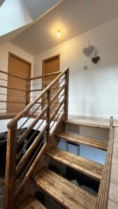 una escalera de madera en una habitación con suelo de madera en Maison de campagne, en Vuillafans