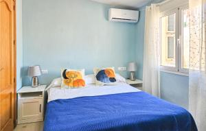 een blauwe slaapkamer met een bed en 2 lampen bij 2 Bedroom Stunning Apartment In Mlaga in Málaga