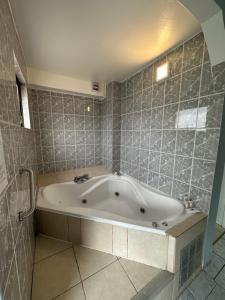 uma banheira na casa de banho com uma parede de azulejos em Red Hotel Centric Santiago em Santiago