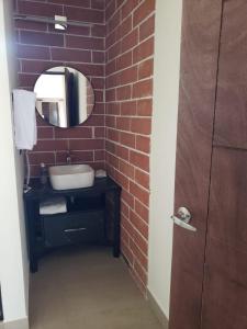 a bathroom with a sink and a brick wall at Ecovergel Santa Lucia in Monterrey