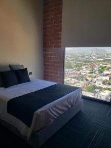 a bedroom with a large bed and a large window at Ecovergel Santa Lucia in Monterrey