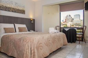 um quarto de hotel com uma cama grande e uma janela em Red Hotel Centric Santiago em Santiago