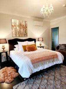 a bedroom with a large bed and a chandelier at Red Door Collective - RDC Vineyard Estate in Pokolbin