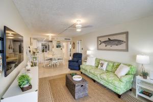sala de estar con sofá verde y mesa en Ocean-View Key Colony Beach Condo with Pool Access! en Key Colony Beach
