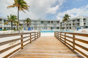 een promenade die leidt naar een resort met een zwembad bij Ocean-View Key Colony Beach Condo with Pool Access! in Key Colony Beach