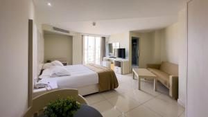 a hotel room with a bed and a couch at Tasia Maris Beach Hotel - Adults Only in Ayia Napa