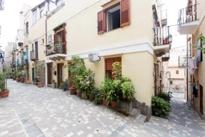 una strada in un centro storico con piante in vaso di ALESSANDRAB&B a Città di Lipari