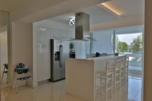 a kitchen with a refrigerator and a counter with stools at Soi's Apartment I in Olympic Beach