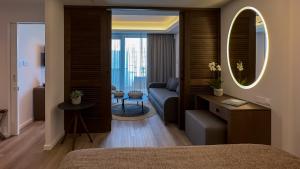 a bedroom with a couch and a living room at Tasia Maris Beach Hotel - Adults Only in Ayia Napa