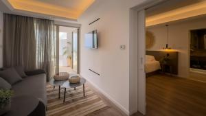 a living room with a couch and a room with a bed at Tasia Maris Beach Hotel - Adults Only in Ayia Napa