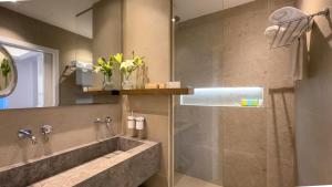 a bathroom with a shower with a sink and a tub at Tasia Maris Beach Hotel - Adults Only in Ayia Napa