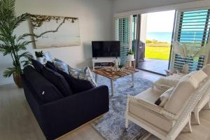 a living room with a couch and a table at Villa by the Sea in Mandurah