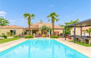 a swimming pool in the backyard of a house with palm trees at Beautiful Home In Septfonds With Outdoor Swimming Pool, Wifi And 1 Bedrooms in Septfonds