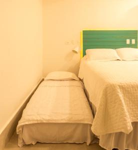 Casa d'Aroeira Residencial Boutique - Centro de Juqueí - 2 quadras do mar - Serviço de Praia - Roupa de Cama 600 fios algodão Egípcio - Toalhas Banho e Praia - Tudo Novo - Estacionamento Interno - Cozinha - Consulte unidades com Ofurô Hidro e Cromoterapia客房内的一张或多张床位
